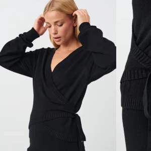 Svart omlottkofta - Säljer en superfin svart omlottkofta med ribbade detaljer. Den har långa ärmar och ett knytband i midjan som ger en snygg passform. Perfekt för både höst och vinter, och funkar lika bra till vardags som till fest. 🖤