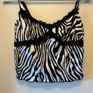 Zebramönstrad linne med spetsdetaljer - Linne med zebra mönster. Storlek M. Nytt skick.