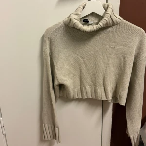 Beige stickad polotröja från H&M - Säljer en superfin beige stickad polotröja i croppad modell. 🍂