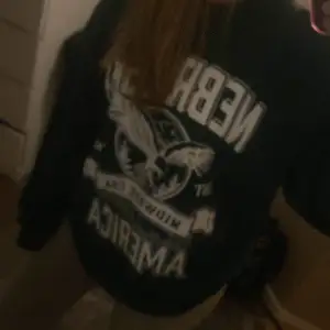 Säljer en oversized sweatshirt med stort tryck av en örn och texten 'Nebraska, Midwest USA'. Perfekt för en avslappnad stil. Tröjan har långa ärmar och är i bra skick. Passar perfekt för höst och vår!