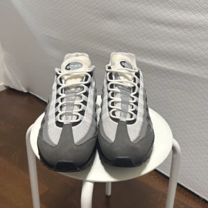 Nike Air Max 95 i grått och vitt - Säljer ett par klassiska Nike Air Max 95 i grått och vitt. Skorna har en snygg design med synlig Air-dämpning i sulan för extra komfort. Skorna är i princip helt oanvända. De är i mycket bra skick.