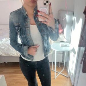 Jeansjacka från Pepe Jeans - Säljer en skitsnygg jeansjacka från Pepe Jeans i bra skick. Den har en cool broderad design på ryggen och klassiska knappar framtill. Perfekt för vår och sommar, och passar till nästan allt! Jackan har fickor. Jackan har en normal passform och långa ärmar. Perfekt för att ge din outfit en avslappnad och trendig look.