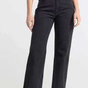 Svarta jeansbyxor - Snygga svarta jeansbyxor i nytt skick. De är högmidjade och har en klassisk straight stil. Helt nya med lappar kvar. 