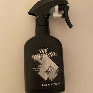 The Comforter Body Spray från Lush - Säljer en 200 ml flaska av The Comforter Body Spray från Lush. Perfekt för att ge en uppfriskande doft av svartvinbär och vanilj. Tagit runt 10 sprut. Nypris 360kr