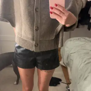 Snygga svarta skinnshorts. Perfekta för en cool och trendig look, oavsett om det är för en utekväll eller en avslappnad dag. De har en normal passform 