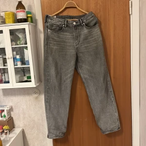 Grå jeans från H&M - Säljer ett par grå jeans från H&M i loose fit. De är i bra skick och perfekta för en avslappnad stil. Passar bra till både vardag och fest. Midjan är midwaist och de har en klassisk femficksdesign. Orginalpris 449