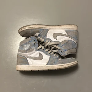 Nike Air Jordan 1 'Hyper Royal' High - Säljer ett par Nike Air Jordan 1 'Hyper Royal' High i bra skick. De har en snygg kombination av blått och vitt med grå detaljer. De är bekväma och stilrena. Kostar 5800 nya men dem är använda ett par gånger och har därför blivit lite cressade.                                       Pris kan diskuteras vid snabb affär.