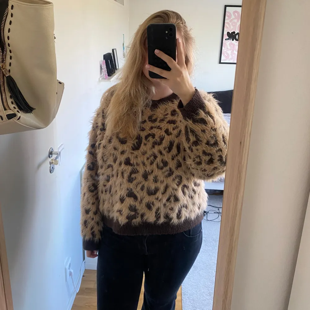 Säljer en supercool och fluffig tröja från H&M i storlek L. Den är beige med ett leopardmönster i brunt och har långa ärmar. Perfekt för att liva upp din höst- och vintergarderob! 🐆✨. Stickat.