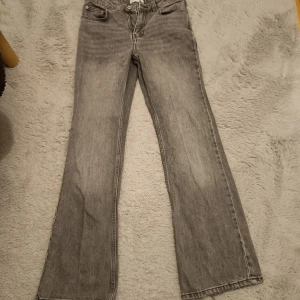 Grå jeans från Gina tricot  - Säljer ett par grå jeans från Gina tricot  i storlek 34. De är bootcut men lite mer straight än vanliga bootcut jeans men dom blir frf bootcut när man har på sig dem! 🖤 Det är lite slitningar längst ner (se bild) så säljer lite billigare. Dem är petite så passar nån som är 155-160!