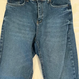 Blå jeans i bra skick - Säljer ett par klassiska blå jeans i bra skick. De har en normal passform och är perfekta för vardagsbruk. Jeansen har fem fickor och en dragkedja framtill. Perfekta för både höst och vår!säljs för 30
