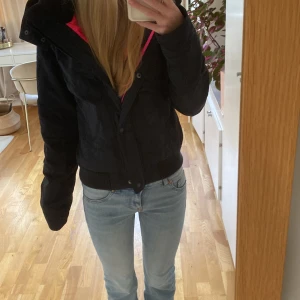 Snygg svart vinterjacka från Hollister - Säljer en svart Hollister-jacka i mycket bra skick. Den har en snygg rosa insida och dragkedja, samt knappar framtill. Perfekt för höst och vinter med sina långa ärmar och bekväma passform. Jackan har en huva och ribbade muddar nertill och upptill (ej vid ärm) för extra bekvämlighet. Den är storlek 34-36, det står M men verkar mer som 36.💗Det finns också avtagbar päls till luvan. Säljer för 300+frakt.