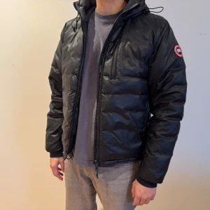 Lodge Hoody dunjacka från Canada Goose - Hej! Säljer min Canada Goose dunjacka, modellen är Lodge Hoody i färgen svart.   Jackan är ca 3,5-4 år gammal, inköpt på NK. Jackan har inte används så mycket, använts  som extra jacka ibland men senaste året har den hängt i garderoben. Bra skick inga skador. Jackan går även att packa ihop till en resekudde.  Jag på bilden är 183cm lång och har storleken medium (M/M)  Nypris ca 9000kr Mitt pris 4000 kr  Jackan finns ca 5 min med bil från Bålsta C men kan även medtags till Stockholm C vissa dagar