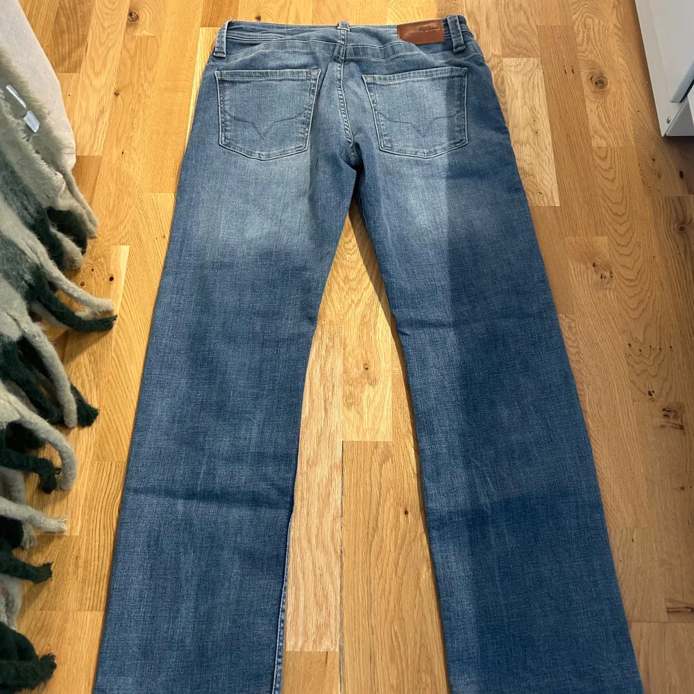 Säljer ett par blå jeans i relaxed fit med normal midja. De har en klassisk femficksdesign och är perfekta för en avslappnad stil. Passar bra till både vardag och helg. Skicket är bra och de är bekväma att bära.. Jeans & Byxor.