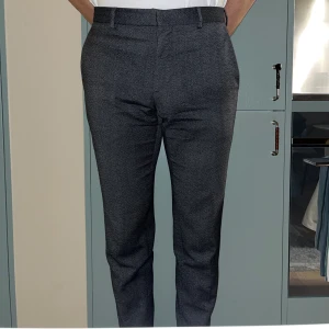 Kostymbyxor - Gråa kostymbyxor den Calvin Klein, storlek 46, fitted. Utsidan är i bra skick, men insidan har en reva, som dock inte syns utåt. Säljes pga för små - jag är 180cm och väger 78kg.