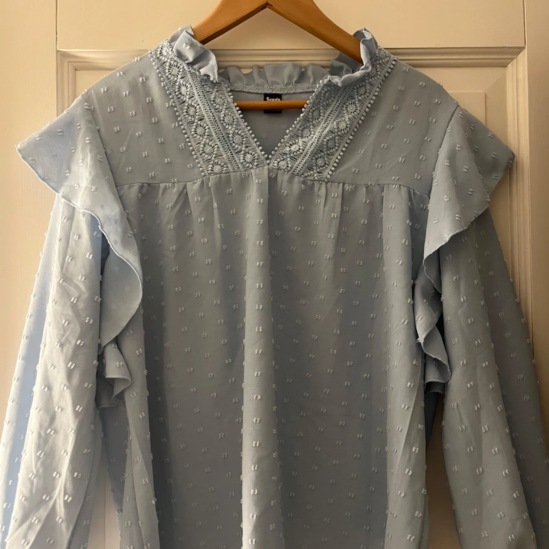 Ljusblå blus med spetsdetaljer