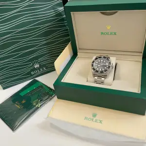 Rolex submariner.  Svepande visare alltså den tickar inte utan ”flyter”. Alla stämplar, certifikat, låda + påse finns.  Har du frågor eller vill se fler bilder + video kontaka mig så ordnar jag det.