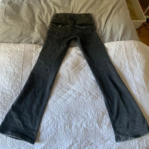 Lågmidjade bootcut Jeans🌟 - Säljer dessa grå/svarta lågmidjade bootcut jeans från gina i storlek 34 då de tyvärr är för små, perfekt skick bara använda några gånger💕