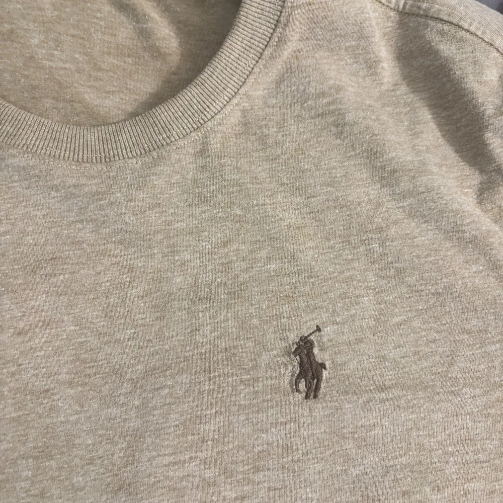 Säljer en stilren kaki t-shirt från Polo Ralph Lauren. Den är kortärmad och har en broderad logga på bröstet. Perfekt för en avslappnad stil, gjord i mjuk bomull för extra komfort. Varan är testat 1 gång och var en present som inte passa min stil.. T-shirts.