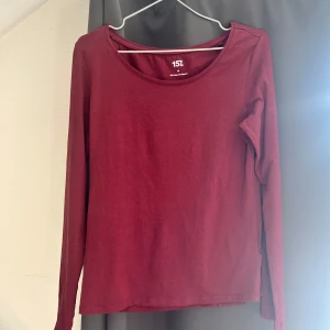 Vinröd långärmad tröja från 157 - Säljer en enkel och stilren vinröd långärmad tröja från 157. Perfekt för höst och vinter, med en skön passform och rund halsringning. Tröjan är i bra skick och passar till både vardag och fest.