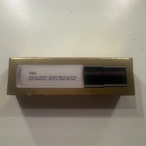 Veil Mineral Primer från Hourglass - Säljer en Veil Mineral Primer från Hourglass med bredspektrum SPF 15. Den kommer i en elegant förpackning och är perfekt för att skapa en jämn bas för smink.