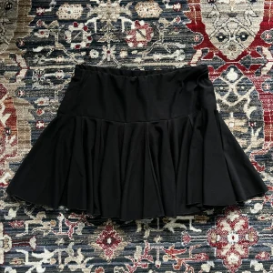 Svart mini kjol med volanger! - Svart mini kjol med volangdetaljer. Perfekt för en stilren look. I perfekt skick! Inga lappar men passar mig som har xs, s! Kjolen har en bekväm passform och är lätt att matcha med olika toppar.