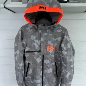 Skaljacka/Skidjacka - Helly Hansen Herr [M] - Väldigt fin skidjacka/skalhybrid. Halva priset från inköp. Perfekt för dig som ska på säsong. Luvan går över hjälm, bra fickor, bättre tech än Gore-tex IMO. DMa för mer info. Har även sändare för +1000kr om du önskar. Skick 8/10 Nypris: 4200kr 
