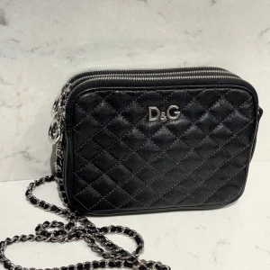 Dolce & Gabbana  - Klassisk vintage väska från exklusiva Dolce Gabbana i quiltat svart skinn med silverfärgade detaljer. Avtagbar axelrem.  Mycket bra skick!  Mått 18x14x5. 