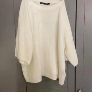 Vit stickad tröja från 157 - Mysig vit stickad tröja från 157 med en avslappnad passform. Perfekt för kyliga dagar med sina långa ärmar och mjuka material. Enkel och stilren design som passar till det mesta.