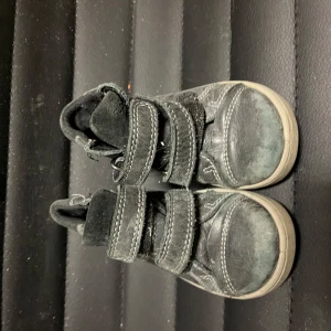 Svarta barnskor med kardborreband - Säljer ett par svarta barnskor från Superfit i storlek 22. Skorna har praktiska kardborreband för enkel på- och avtagning samt en robust sula för bra grepp. Perfekta för aktiva barn!