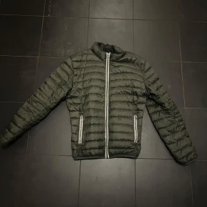 Grön pufferjacka från Colmar - Snygg olivgrön jacka från Colmar • Storlek 52 som motsvarar L • Skriv vid frågor • Använt ett fåtal gånger, bra skick med inga defekter 