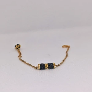 Guldarmband med svarta pärlor - Elegant guldarmband med svarta pärlor och gulddetaljer. Armbandet har en fin kedja och ett dekorativt lås. Perfekt för att ge en stilren touch till din outfit.