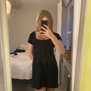 Svart kortklänning med knappar - Snygg svart kortklänning med knappar framtill och korta ärmar. Super skön och luftig, perfekt till sommaren! Säljer då jag inte använder den och är använd en gång💗