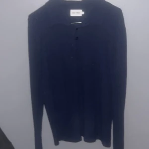 Mörkblå tröja från East West - Säljer en stilren mörkblå tröja från East West. Tröjan har långa ärmar och en klassisk design med knappar framtill. Perfekt för en avslappnad och snygg look.