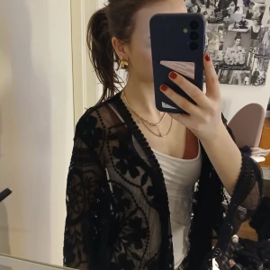 Svart spetsjacka - Snygg svart spetsjacka med blommigt mönster. Jackan är genomskinlig och har långa ärmar. Osäker på storlek och märke då den saknar tagg, men passar mig bra som brukar bära xs/s🥰