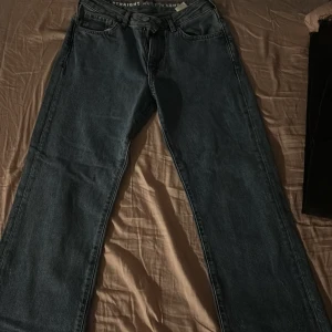 Blå jeans med rak passform - Säljer ett par klassiska blå jeans med rak passform. De har en dragkedja och knapp framtill samt fem fickor. Perfekta för en avslappnad stil.