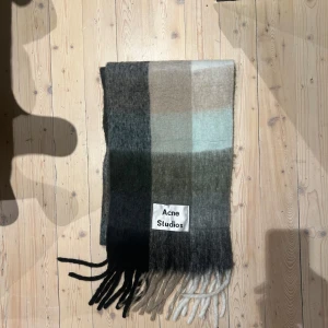 Acne Studios Halsduk - Unisex, man, kvinna halsduk från Acne Studios i olika nyanser av grått, beige och blått. Nypris 3100kr. Köpt i London. Aldrig använd. Storlek: 225x35cm