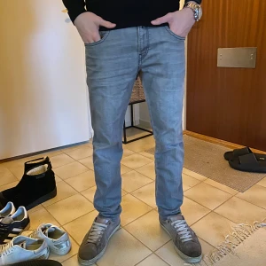 Grå Replay anbass jeans - Säljer ett par tvär feta Replay jeans i färgen ljusgrå. Jeansen är slimfit och är i anbass modellen. Jeansen är uppsydda ungefär 5-6 cm och är i använt men bra skick. Modellen är 177cm och väger 61 kg. (Nypris 1400) Mitt pris 599