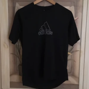 Svart tränings t-shirt från Adidas - Snygg svart tränings t-shirt från Adidas med det klassiska logotyptrycket på framsidan. (logan är lite utsliten) 