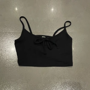 Svart linnetopp från Bik Bok - Säljer en svart linnetopp från Bik Bok med smala axelband och knytning framtill. Skriv privat för fler bilder eller frågor :) 