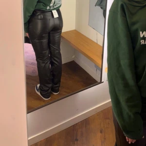 Svarta skinnbyxor - Snygga svarta skinnbyxor som inte kommer till använding, använd några få gånger men är som nya! det är storlek 34 men skulle säga att det är mer åt 36!