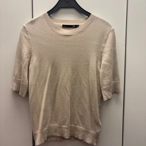 Beige tröja från Lager 157 - Säljer en stilren beige tröja från 157 i storlek XS. Tröjan har en rund halsringning och korta ärmar, perfekt för en avslappnad look. Materialet känns mjukt och bekvämt.