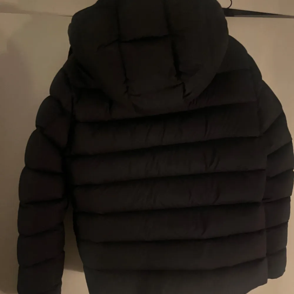 HELT 100% ÄKTA QR KOD SAMT LAPPARNA FINNS, KAN LÖSA MER BILDER I PM. Snygg svart dunjacka från Moncler med stor logga framtill. Jackan har en quiltad design och är långärmad med huva. Perfekt för kyliga dagar. 19500 NYPRIS, STEAL!. Takit.