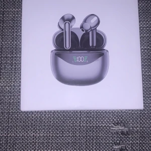 Trådlösa hörlurar med laddningsetui - Säljer ett par snygga trådlösa hörlurar med ett digitalt display-laddningsetui. Hörlurarna har bra ljudkvalitet och super bas. Perfekt för musikälskare och de som är på språng. Laddningsetuiet visar batterinivån så du alltid har koll. Köp nu och njut av trådlös frihet!