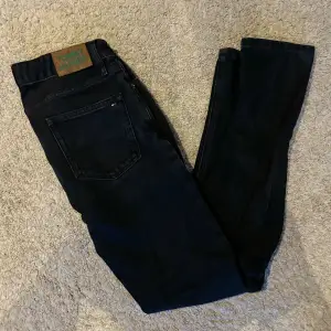 Säljer ett par snygga svarta jeans från Tommy Hilfiger. De har en klassisk design med fem fickor och en knappgylf. Perfekta för både vardag och fest!