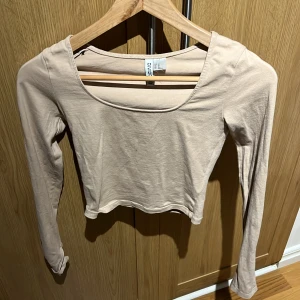 Beige tröja - Säljer en beige tröja från hm som sitter lite tajtare och är ganska kort i magen, långa armar med en slits och en rund urringning. Säljer pågrund utav att den inte kommit till användning. St xs, inte alls förstörd eller tecken på användning