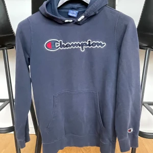 Hoodie  - Säljer denna champion hoodie som är i bra kvalitet. Tröjan är använd men är i bra skick. Inga defekter. Kan vara aningen liten i storleken 