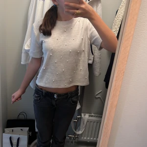  Beige t-shirt med pärlor på -  En stickad beige t-shirt med små vita pärlor på från Sara i storlek S💗 (Det finns inga pärlor på baksidan)