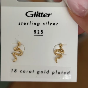 Guldpläterade ormörringar från Glitter - Snygga ormörringar i sterling silver från Glitter, pläterade med 18 karat guld. Perfekta för att ge en edgy touch till din outfit. De är små och diskreta men ändå iögonfallande med sin unika design. Säljer matchande ring till på mitt konto 