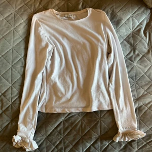 Vit tröja - Säljer denna fina tröja från Nakd i stl S, material är lite tjockare och tröjan har volanger på armarna💕💕