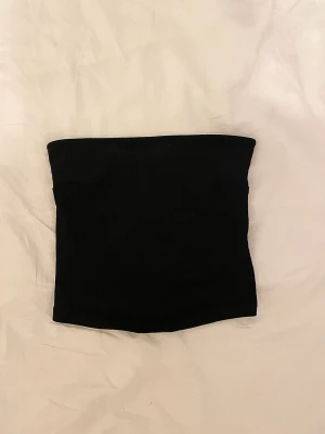 Svart tubtop  - Fin tubtop i storlek M från Gina tricot! Kommer aldrig till användning och har enbart används ett fåtal tillfällen, därav bra skick. Toppen har en gummikant som gör att den inte faller ner. Pris kan diskuteras 🌸🌸
